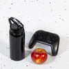 A drink bottle in black with a flip straw lid, accompanied by a red apple and a black gaming controller.