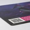 A counter mat featuring a vibrant design with shades of purple and black, displaying a QR code and a logo.