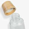 A glass drink bottle with a bamboo lid. The bottle has an octagonal shape and is transparent.