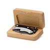 A black multi-tool is housed in a wooden box, showcasing its sleek design and metallic components.