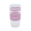 A reusable coffee cup in clear and pink, featuring a silicone band and a lid, with a logo on the side.