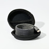 A charging cable in a round black case, featuring a sleek, woven design in grey tones.