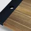A wooden serving board with a textured black edge and a circular cutout, showcasing natural wood tones.