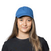 A blue organic washed cotton cap displayed on a model, featuring a logo on the front.