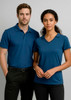 A blue women's short sleeve polo shirt displayed on a model, featuring a v-neck design and a logo.