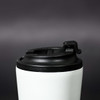 A travel mug featuring a white body and a black lid, with a logo visible on the surface.