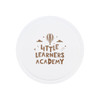 A round white promotional item featuring the text "Little Learners Academy" in brown with a hot air balloon and stars.