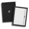 A white notebook in a black gift box, featuring a branding logo and a closure strap.