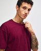 A maroon American Apparel Super Heavyweight T-Shirt displayed on a model with short hair and a neutral background.