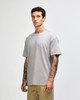 A grey super heavyweight T-shirt displayed on a model, featuring a simple design and straight fit.