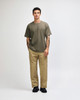 A model wearing an olive green American Apparel Super Heavyweight T-Shirt and matching cargo pants, paired with white sneakers.