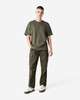 A model wearing an olive green American Apparel Super Heavyweight T-Shirt and matching cargo pants, paired with white sneakers.