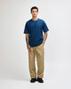 A model wearing a navy blue American Apparel Super Heavyweight T-Shirt paired with olive green cargo pants.