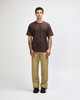 A model wears a brown American Apparel Super Heavyweight T-Shirt paired with olive green cargo pants and sneakers.