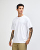 A white American Apparel Super Heavyweight T-Shirt displayed on a male model in a relaxed pose.