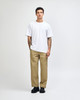A man wearing a plain white American Apparel Super Heavyweight T-Shirt paired with light blue jeans and black shoes.