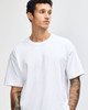 A model wearing a plain white American Apparel Super Heavyweight T-Shirt. The shirt has a casual fit and features a logo.