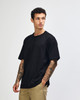 A model wearing a black American Apparel Super Heavyweight T-Shirt, paired with olive green cargo pants.