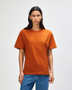 A man wearing an orange American Apparel Super Heavyweight T-Shirt, standing against a plain background.