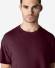 A maroon Gildan Light Cotton T-Shirt displayed on a model. The shirt has a classic crew neck and short sleeves.