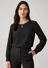 A black long sleeve blouse with a keyhole neckline, paired with tailored trousers. It has a simple, elegant design.