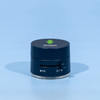 A black and silver device with a logo on top and a dial on the side, resting on a blue background.