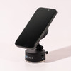 A black vacuum suction magnetic phone stand with a sleek design, featuring a logo on its base.
