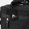 A black canvas cooler bag featuring a zippered compartment and a branded tag.