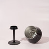 A black, detachable wine glass with a broad bowl and a separate stem. It features a logo on the base.