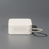 A compact white portable Bluetooth speaker with a textured carrying loop and control buttons on the side.