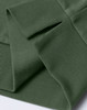 A close-up of a green unisex crew neck sweater, highlighting the ribbed cuffs and hem. The fabric appears soft and comfortable.