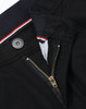 A close-up of black chino pants featuring a zip fly and button closure, with a striped waistband detail.