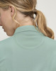 A close-up of a woman's neck and back, featuring a light green polo with a collar and a textured pattern.