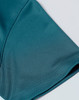 A close-up of a teal jacquard knit fabric featuring a smooth texture and subtle pattern, with a logo present.