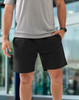 Unisex mercerised cotton shorts in black, featuring side pockets and a comfortable fit, paired with a grey top.