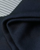A close-up of textured, dark navy fabric with a ribbed pattern, showcasing its soft and flexible quality.