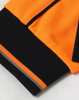 A close-up of an orange and black long-sleeve polo shirt featuring a logo and contrasting cuffs.