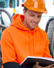 A bright orange and black water-resistant fleece hoodie with a hood, worn by a person in safety gear, reading a book.