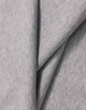 A close-up of light grey cotton fabric, showcasing its soft texture and smooth finish. The fabric has a logo.