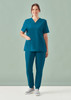A women's teal V-neck scrub top paired with matching scrub pants, featuring a logo on the top.