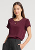 A maroon women's short sleeve blouse with a keyhole detail at the neckline, paired with black trousers.