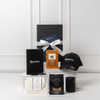 A gift pack featuring a black cap, notebook, candle, and assorted packaged items, all presented in a sleek box with a bow.