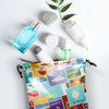 A large satin gift bag in vibrant colours, surrounded by various skincare and cosmetic containers.