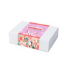 A gift box with a pastel pink design featuring bunny illustrations and decorative patterns, secured with a printed band.