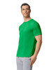 A green adult t-shirt on a model, featuring a crew neck and short sleeves, with a logo on the sleeve.