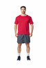 A man wearing a red Gildan Performance adult t-shirt and grey shorts, standing in a relaxed pose.
