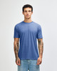 A blue American Apparel tri-blend t-shirt displayed on a model, featuring a relaxed fit and short sleeves.