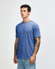 A blue tri-blend T-shirt displayed on a male model with tattoos, featuring a round neckline and short sleeves.