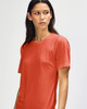 A red American Apparel Tri-Blend T-Shirt displayed on a model with long hair, featuring a simple design and short sleeves.