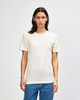 A cream-coloured American Apparel Tri-Blend T-shirt displayed on a model, featuring a simple design and fitted style.